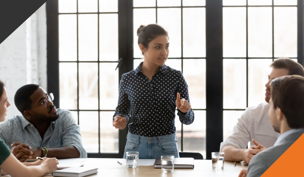 a corporate training session led by a coach with four employees to harness the power of internal trainers