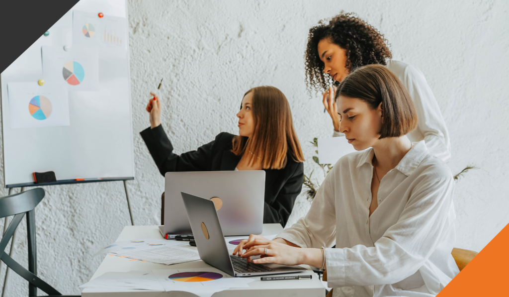 3 employees in an meeting reviewing reflecting on year-end results