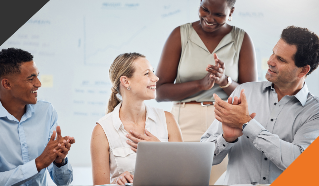 a female employee standing in front of a computer in a shared workspace displaying self-awareness