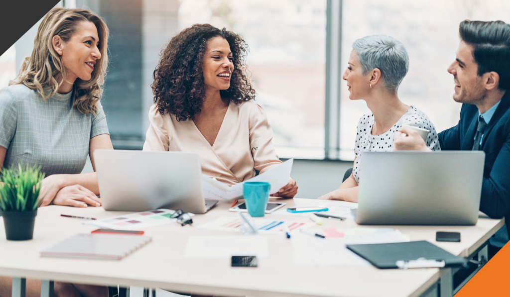 4 employees seated around a table discussing successfully implementing resolutions