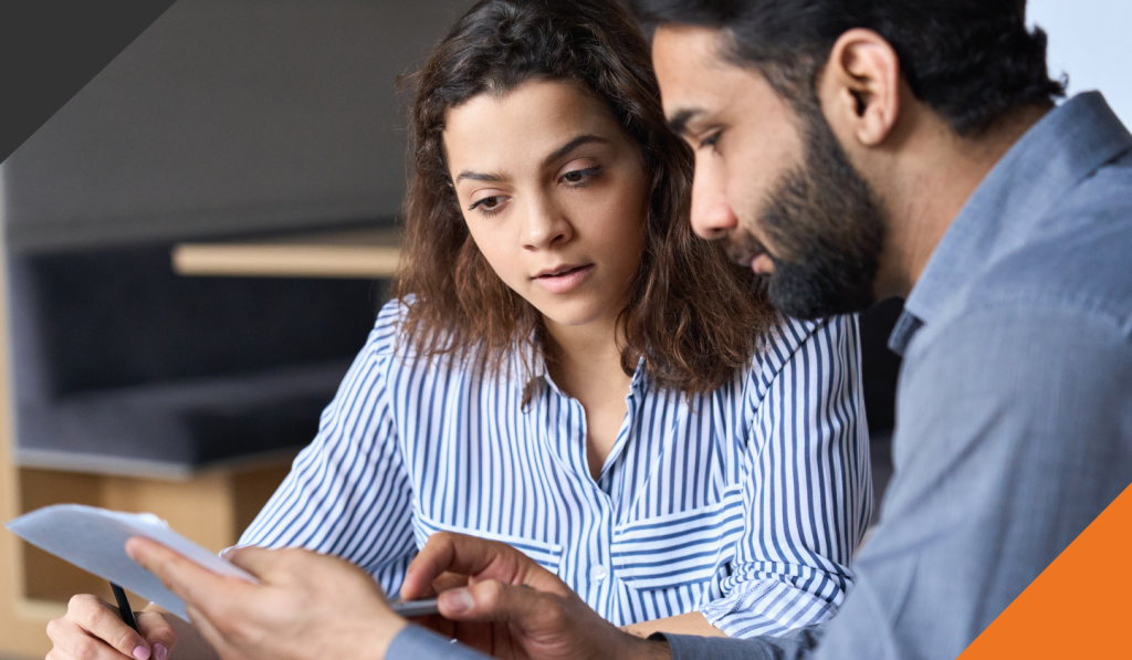 two employees seated at a table coming to an understanding of how to accept and navigate conflict