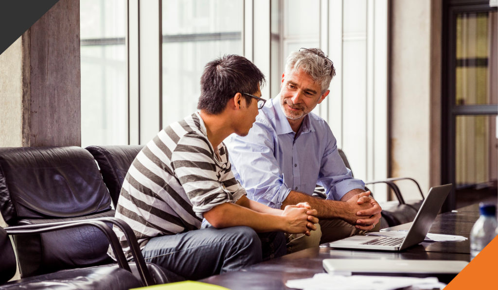 two co-workers seated at a desk discussing how to build a network of resilience