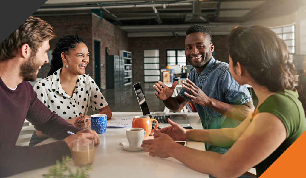 four employees seated in a meeting collaborating to determine what is an inclusive workplace culture